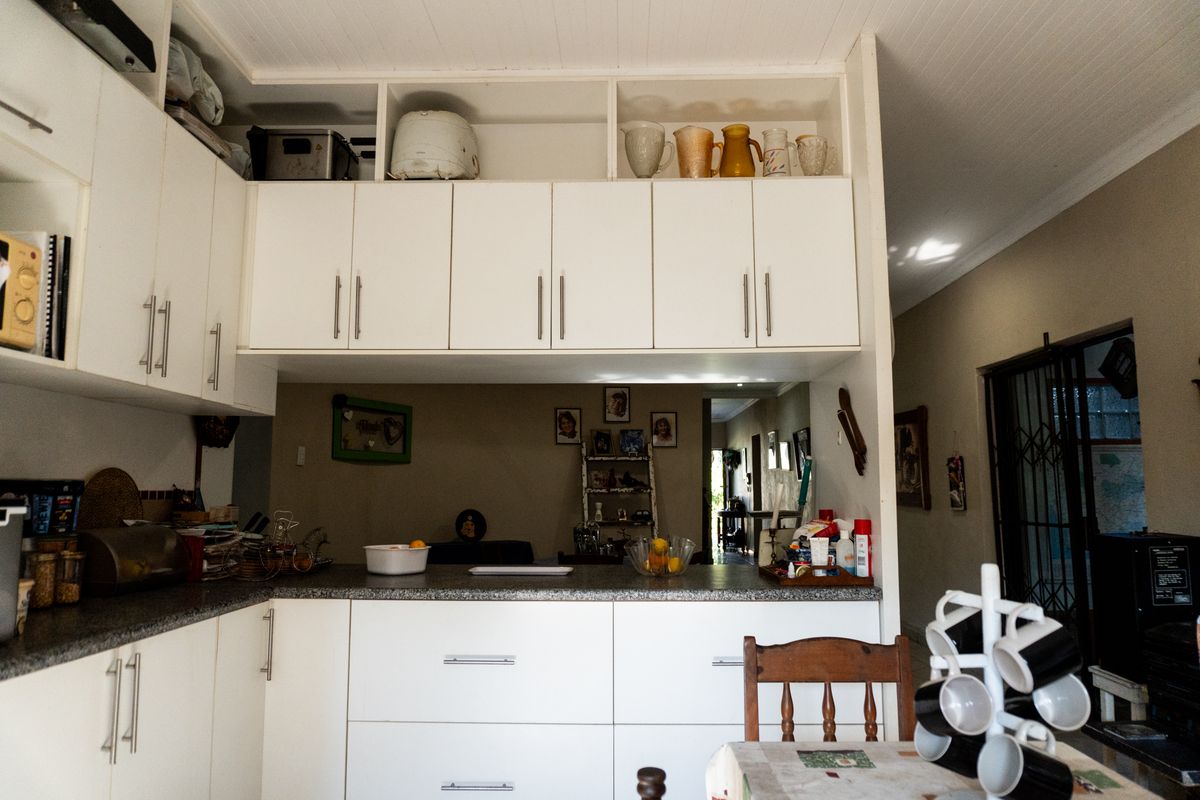 A functional kitchen featuring white cabinetry, ample overhead storage, and a laminate countertop, providing a practical workspace with an open-plan layout.