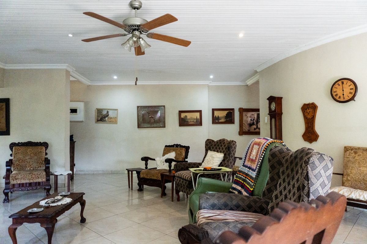 Spacious living room featuring tiled flooring, a ceiling fan, and recessed lighting, offering a comfortable and functional layout.
