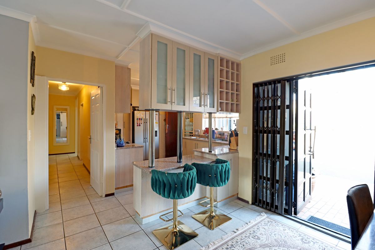 A functional kitchen featuring granite countertops, built-in cabinetry with a wine rack, and a breakfast bar, with direct access to an outdoor area.