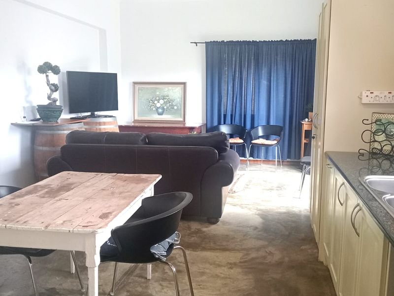 Open plan living and kitchen area featuring granite countertops, double bowl sink, and concrete flooring in a functional townhouse layout.