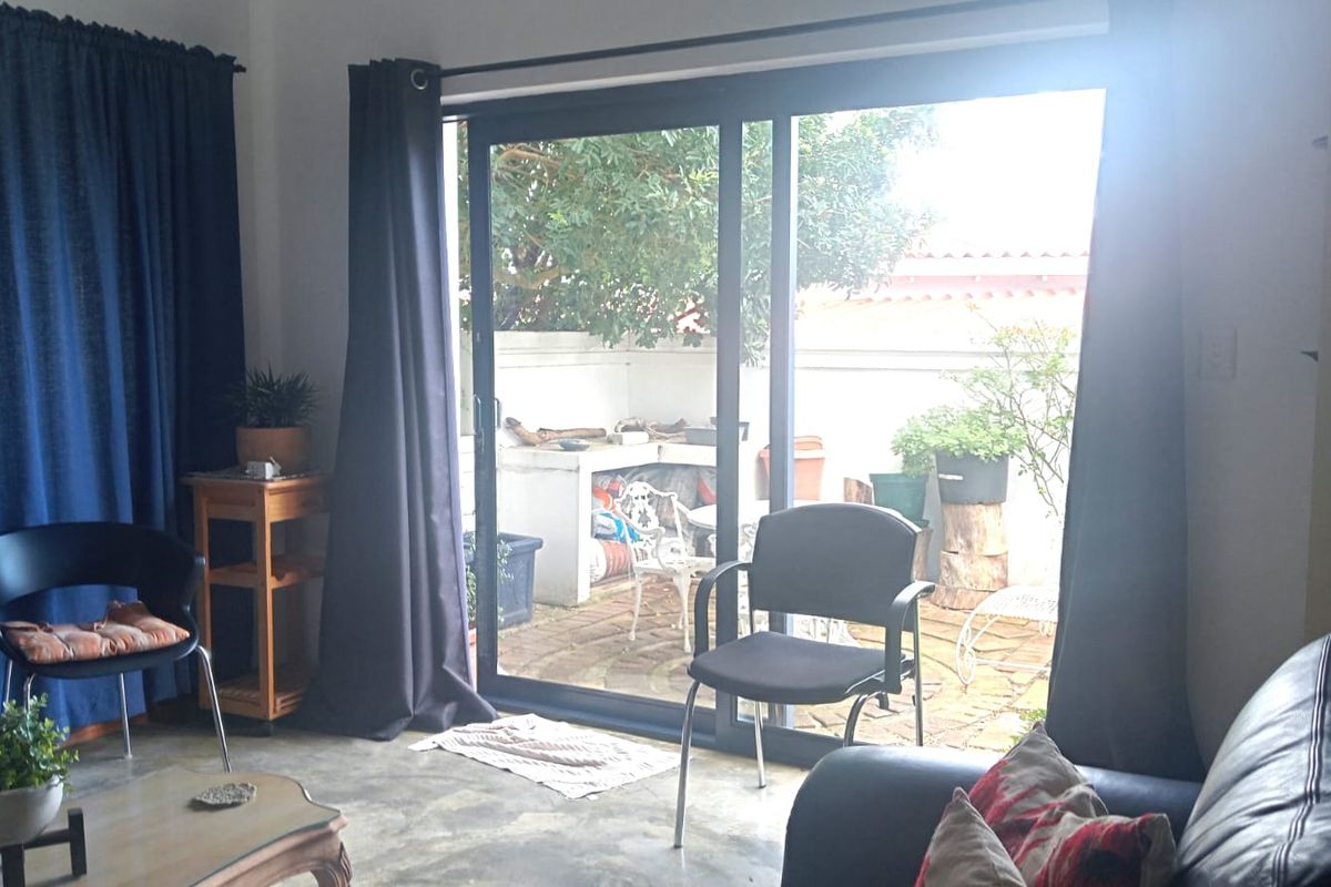 Living room featuring polished concrete floors and large sliding glass doors providing direct access to an outdoor patio area.