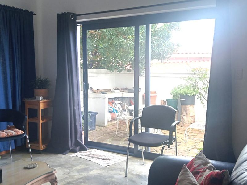 Living room featuring polished concrete floors and large sliding glass doors providing direct access to an outdoor patio area.