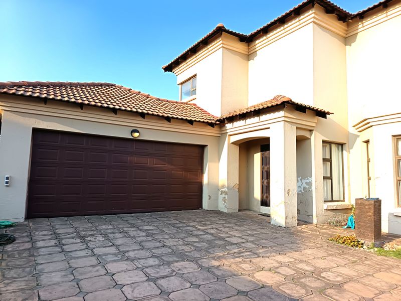 Front elevation of a double-story house featuring a paved driveway, double garage, and covered entrance area.