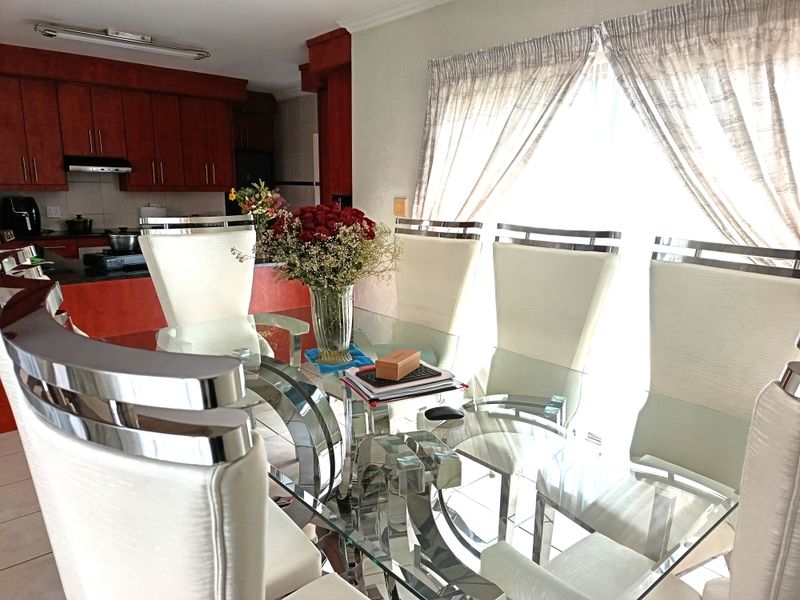 Open plan dining area adjacent to a kitchen featuring dark wood cabinetry and granite countertops.