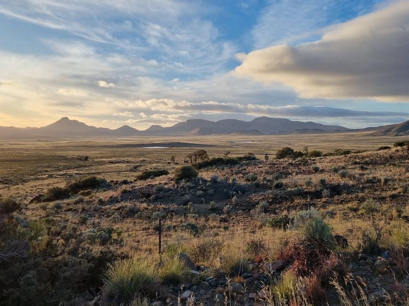 A scenic landscape view showcasing the expansive natural terrain and mountain range surrounding the farm property.