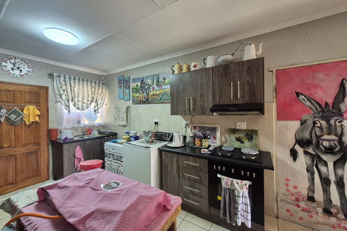 A functional kitchen featuring wood-look cabinetry, a built-in oven with extractor fan, and tiled flooring, offering a practical layout for daily meal preparation.