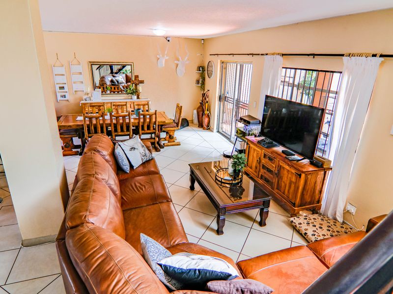 An open-plan living and dining area featuring tiled flooring and sliding glass doors leading to an outdoor space.