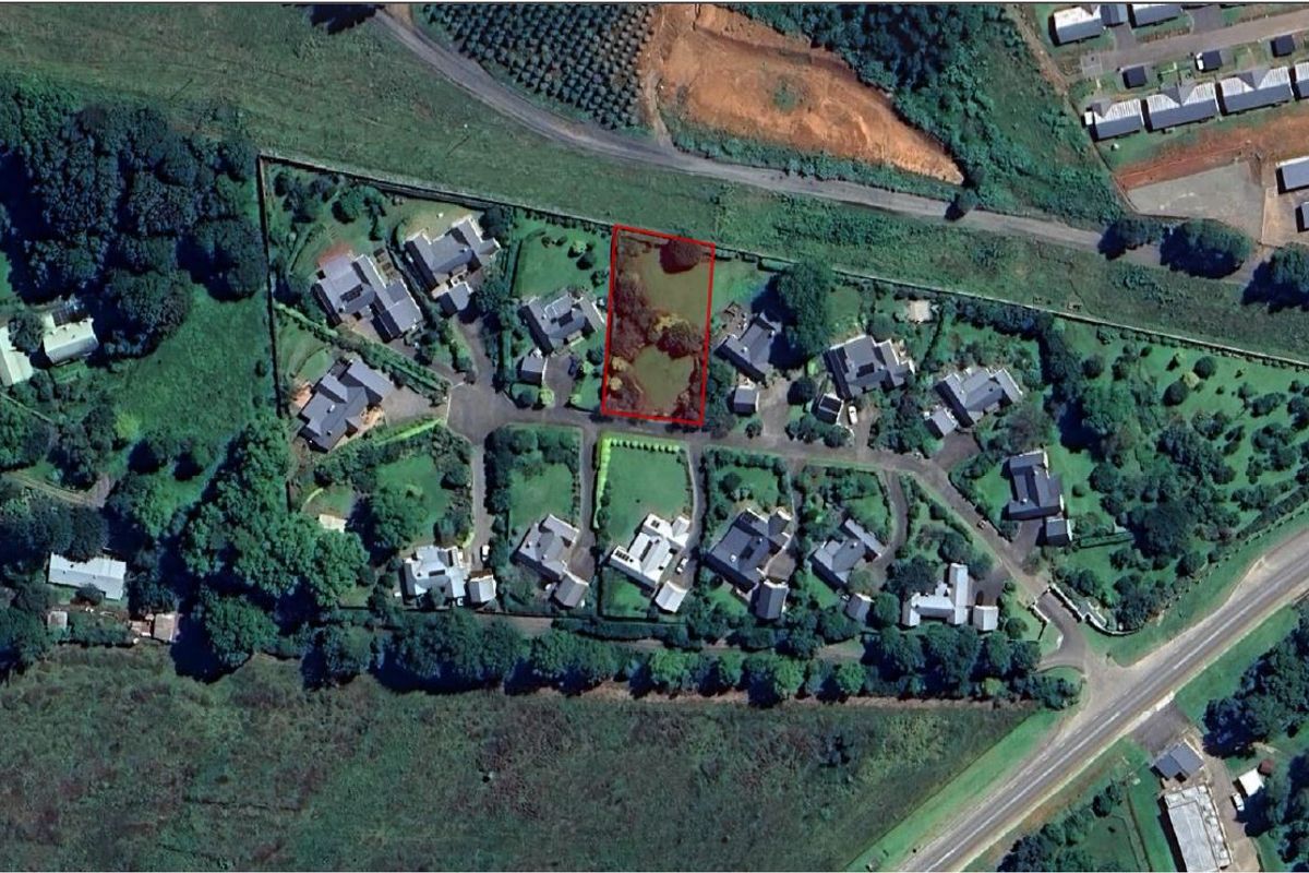 An aerial view of a vacant residential plot within a developed estate, highlighting the property boundaries and surrounding neighborhood context.