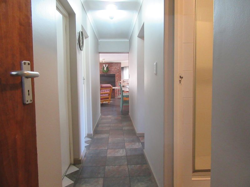 A functional hallway featuring tiled flooring and neutral wall finishes, providing access to adjacent rooms within the home.