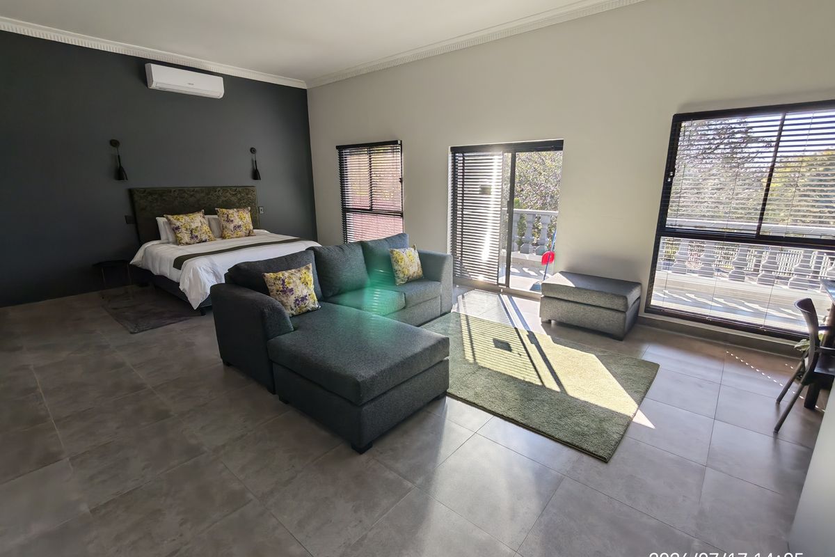 Spacious bedroom featuring tiled floors, a split-system air conditioner, and sliding glass doors leading to a balcony with natural light.