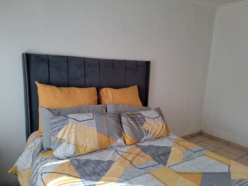 A bedroom featuring tiled flooring and coved ceiling details, providing a neutral foundation for personal styling.