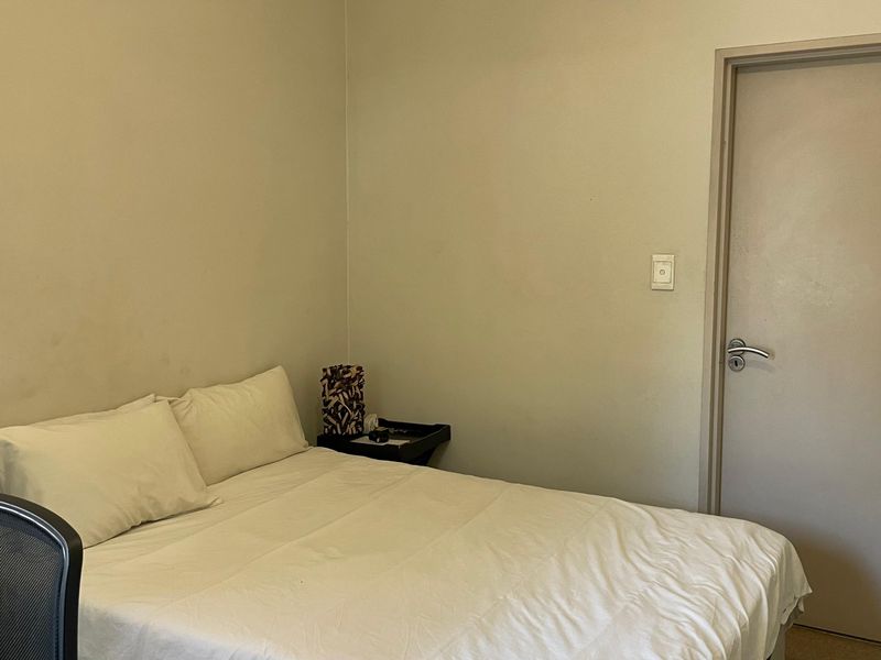 A standard bedroom featuring neutral wall finishes, an internal door, and a light switch.