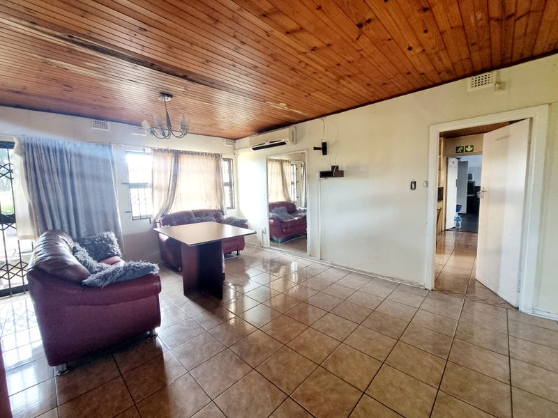Living room featuring ceramic tiled flooring, a timber tongue and groove ceiling, and a wall-mounted split system air conditioner.