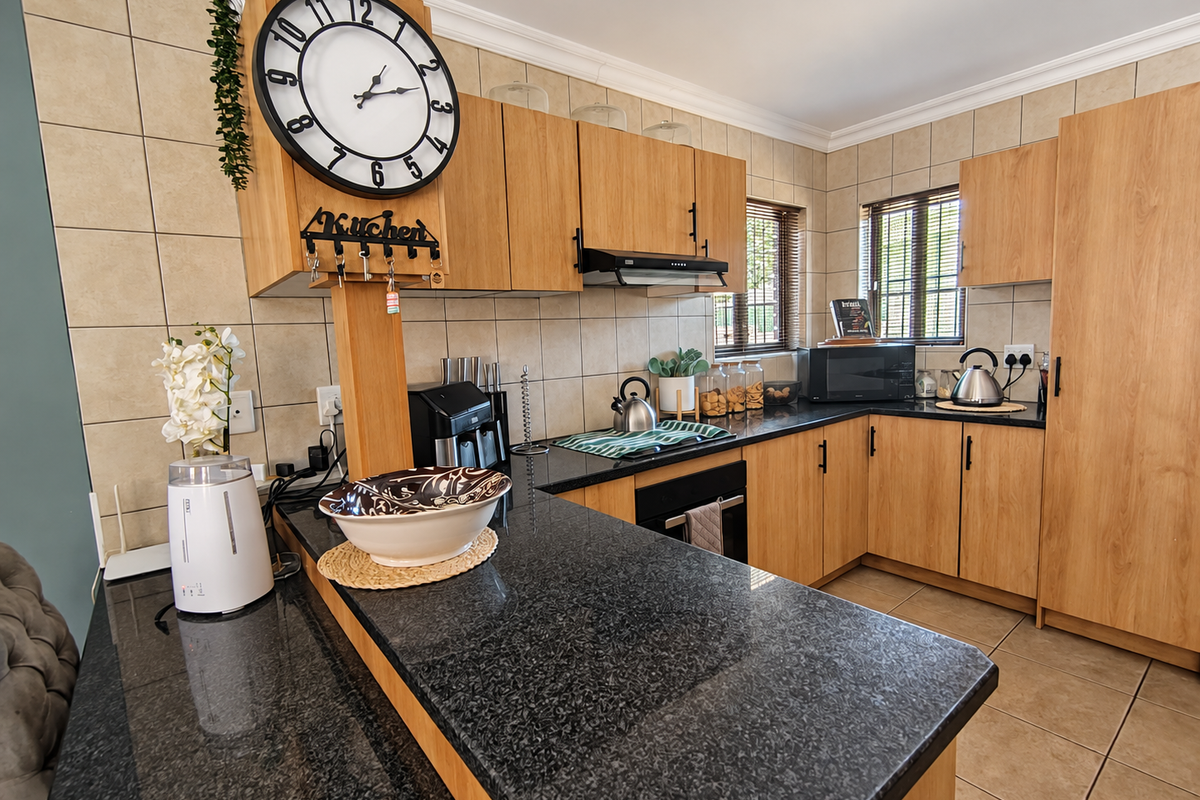 A functional kitchen featuring wooden cabinetry, granite countertops, a built-in oven, and a tiled backsplash, offering a practical and well-maintained workspace.