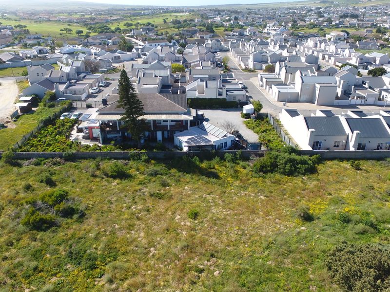 Aerial view of the guest house property showing the building layout, roof structure, solar panels, and surrounding residential estate context.