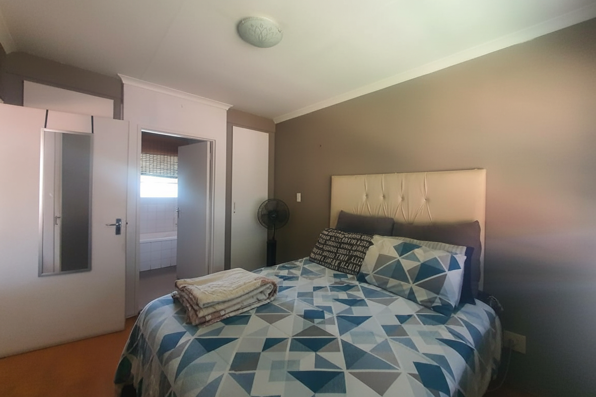 A bedroom featuring built-in cupboards and direct access to an en-suite bathroom.