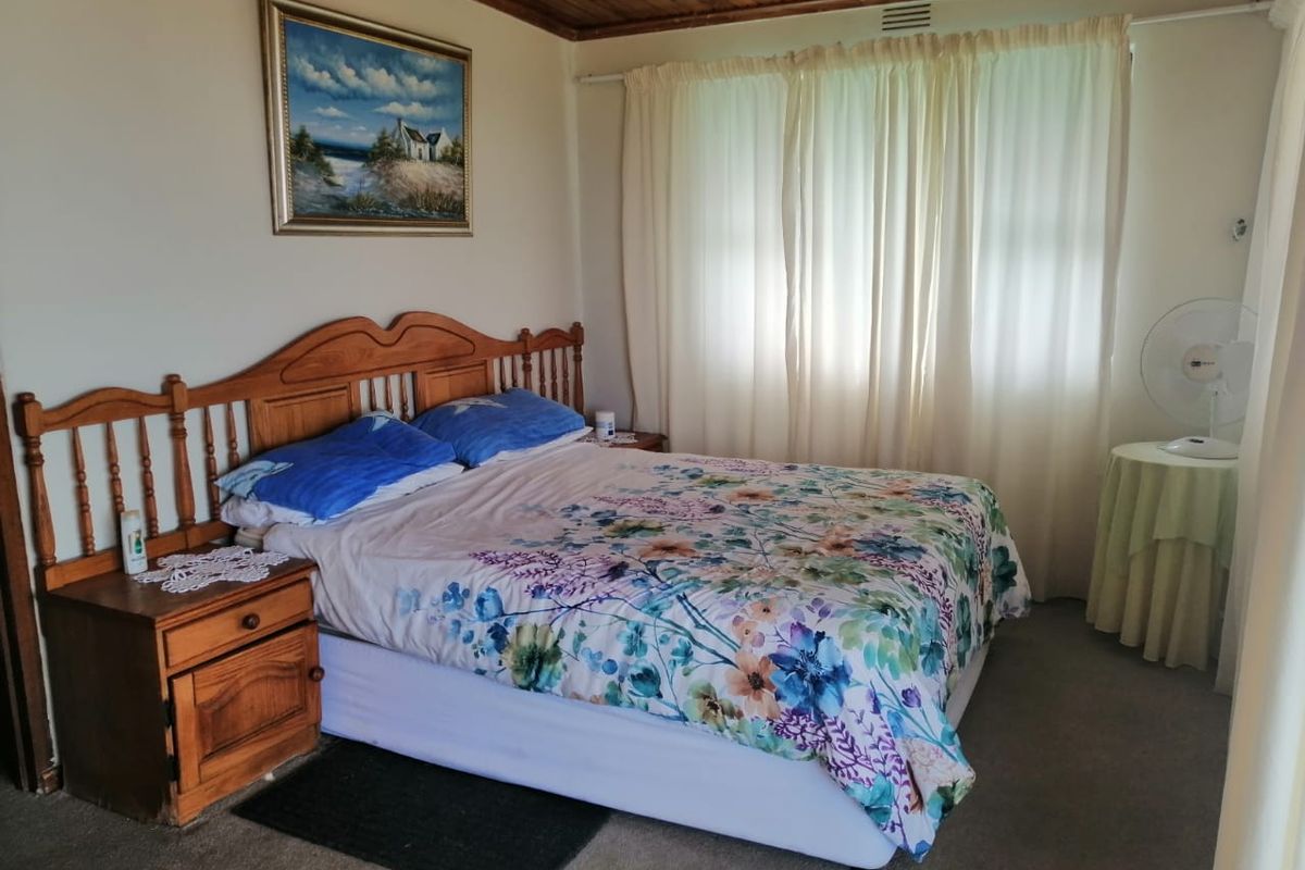 A bedroom featuring a timber-paneled ceiling and neutral wall finishes, offering a functional space with natural light.