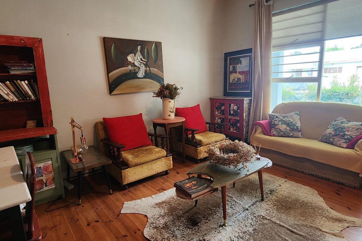A cozy living room featuring warm timber flooring and a large window that allows for natural light.