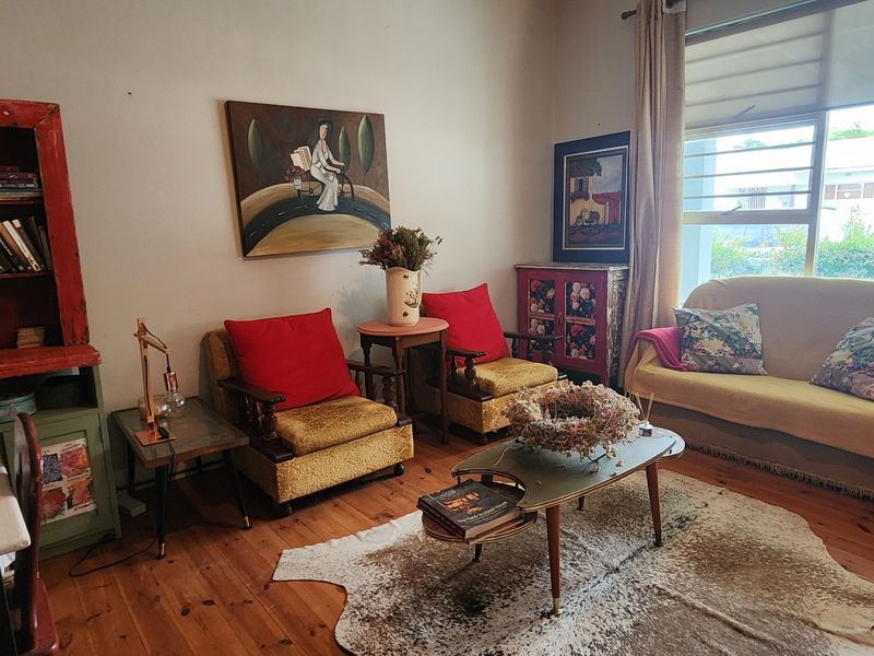 A cozy living room featuring warm timber flooring and a large window that allows for natural light.