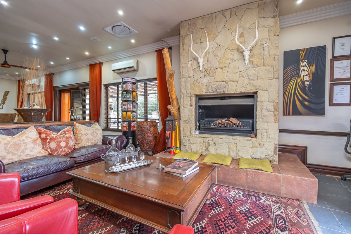 A cozy living room featuring a prominent stone-clad fireplace, tiled hearth, and recessed lighting, creating a warm and inviting atmosphere.