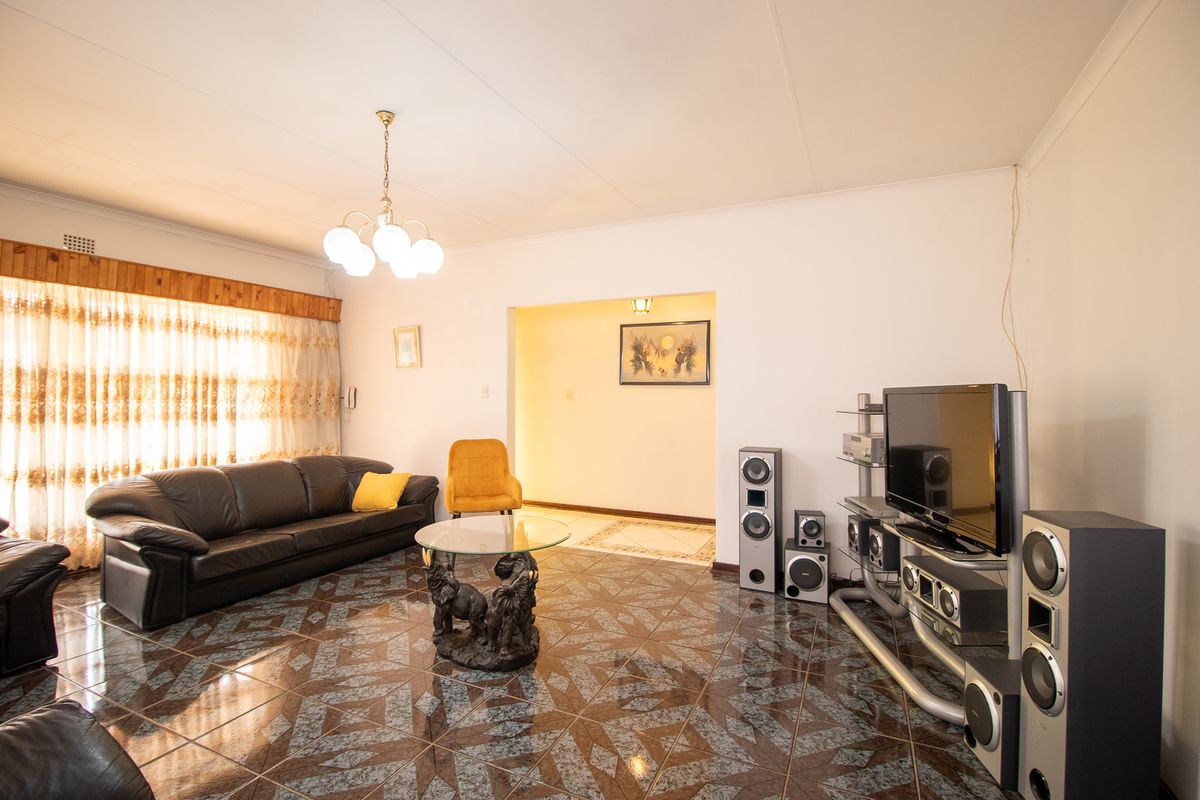 Spacious living room featuring patterned tiled flooring and a coved ceiling, providing a functional and well-lit area for relaxation.
