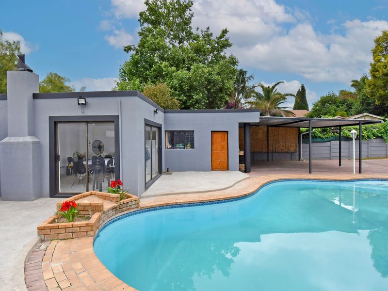 Outdoor pool area featuring a swimming pool with brick coping, a covered patio space, and direct access to the home via sliding glass doors.
