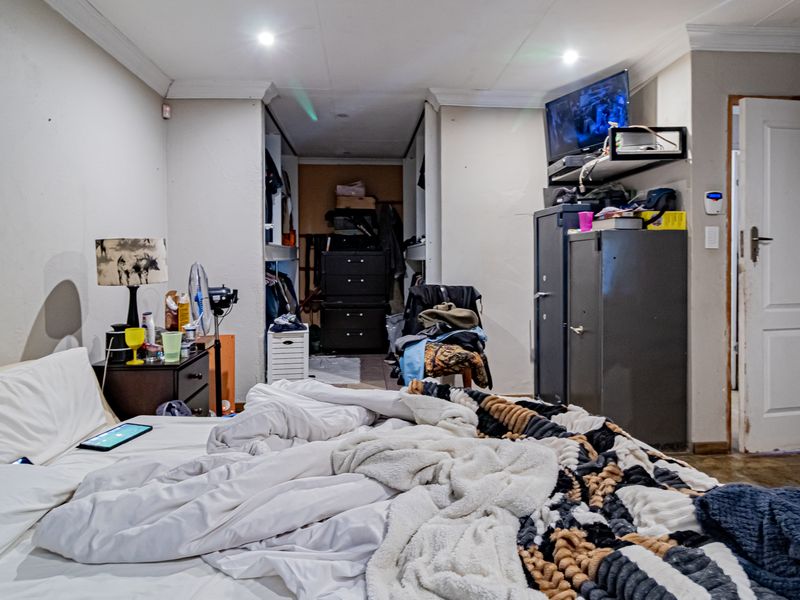 A bedroom featuring recessed ceiling lighting, coving, and built-in cupboard storage space.