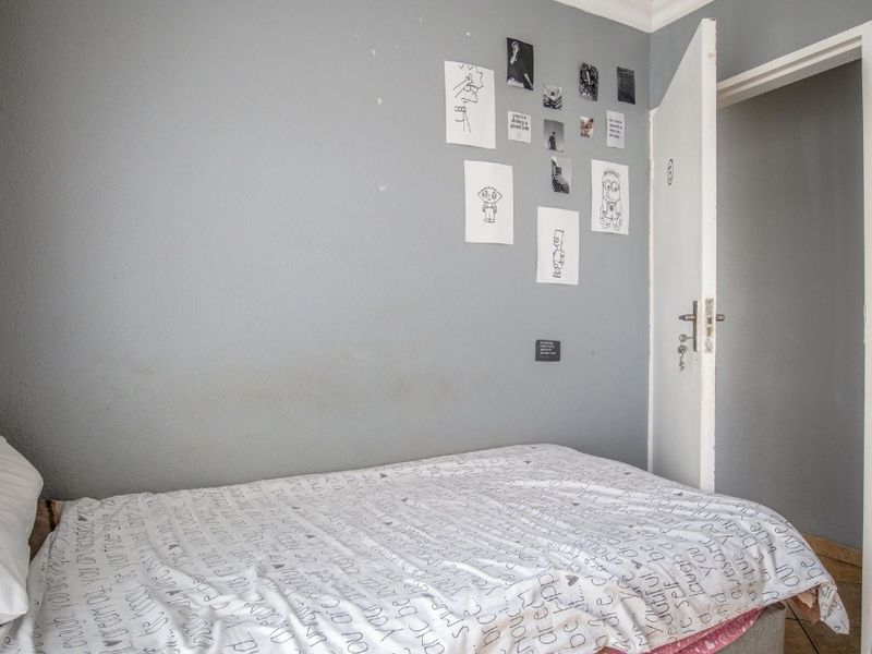 A standard bedroom featuring grey painted walls, coving, and a single internal door access.