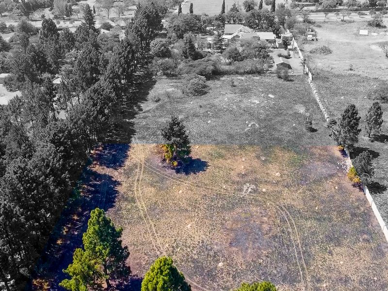 Aerial view of a large, undeveloped small holding plot featuring mature trees and perimeter fencing, offering significant potential for development.