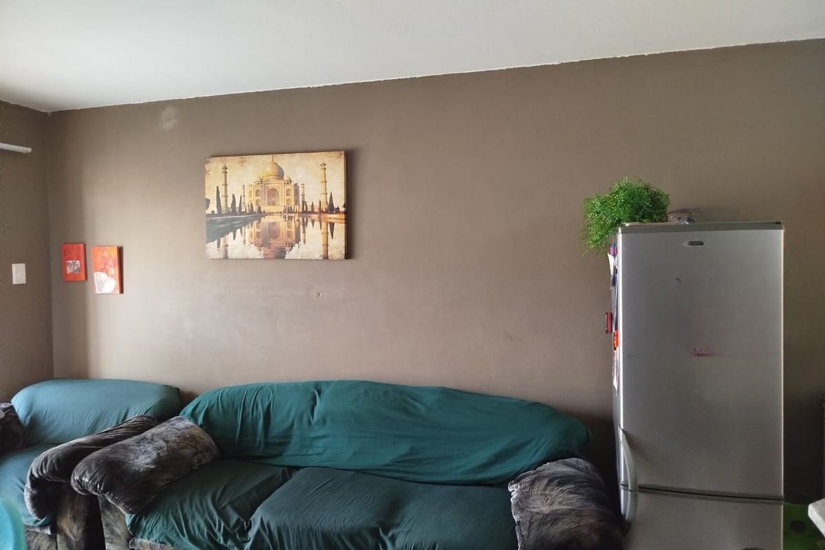 A living room area featuring brown painted walls and tiled flooring, providing a neutral base for potential interior updates.