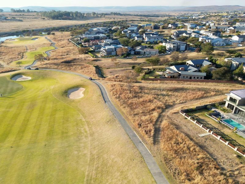An aerial view of a residential estate bordering a golf course, showcasing the surrounding landscape and neighborhood layout.