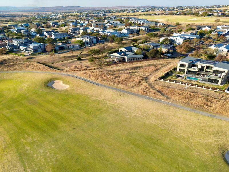 Aerial view of a residential estate bordering a golf course, showcasing the surrounding landscape and neighborhood layout.