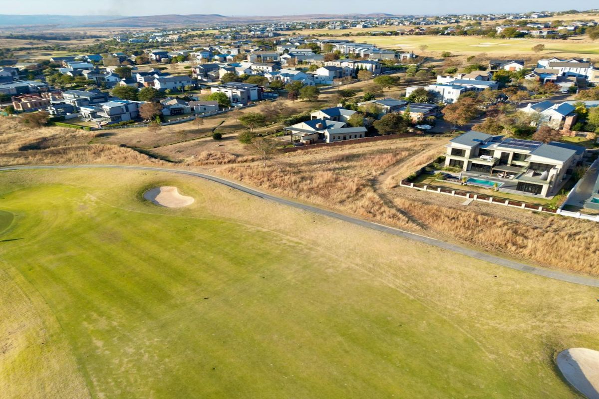 Aerial view of a residential estate bordering a golf course, showcasing the surrounding landscape and neighborhood layout.