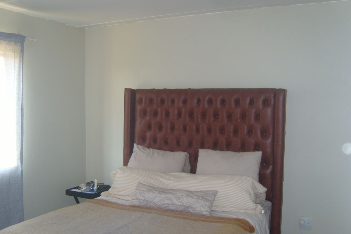 A simple bedroom featuring neutral wall finishes and a single electrical outlet.