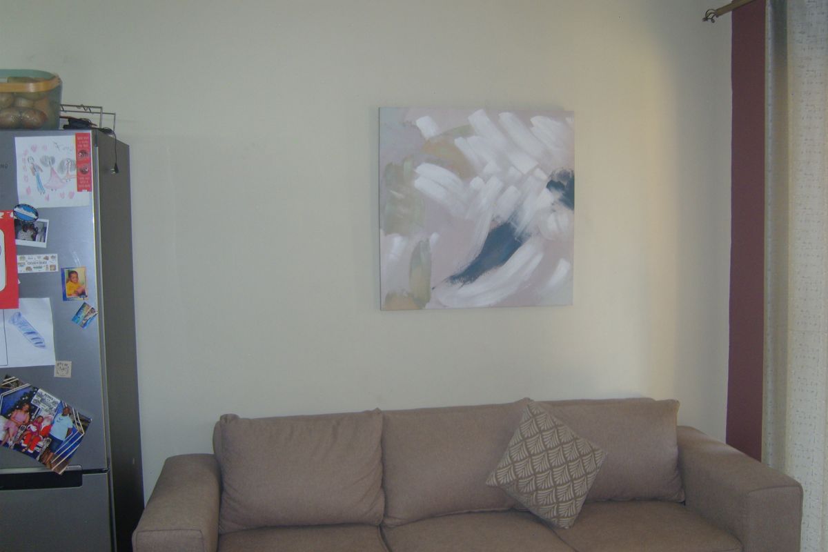 A living room area featuring neutral wall finishes and a curtain rod, providing a functional space for relaxation.