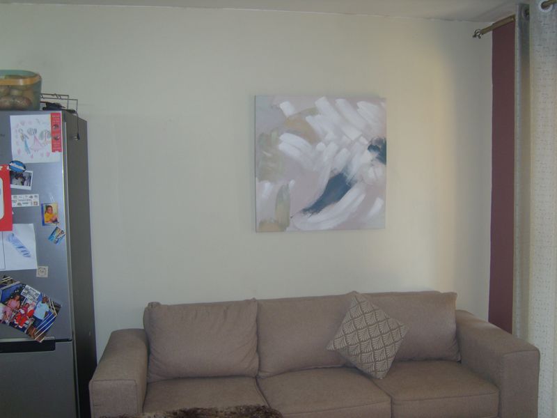 A living room area featuring neutral wall finishes and a curtain rod, providing a functional space for relaxation.