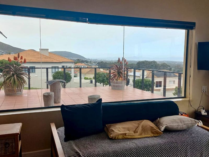Living room featuring a large picture window with expansive views and direct access to a tiled balcony.