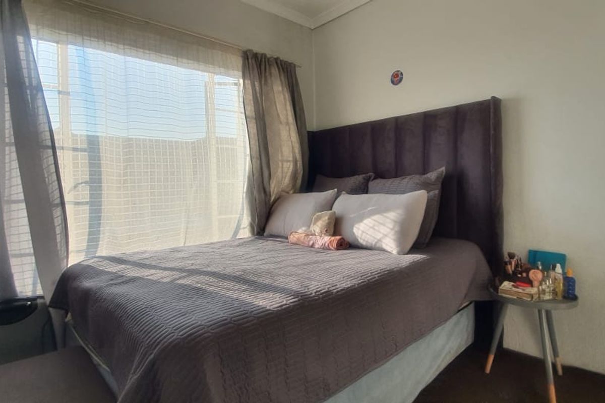 A cozy bedroom featuring a large window that allows for ample natural light, creating a bright and inviting atmosphere.