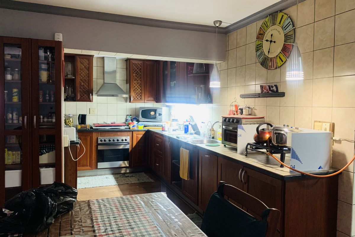 A functional kitchen featuring dark wood cabinetry, stainless steel appliances, tiled backsplash, and ample counter space for meal preparation.