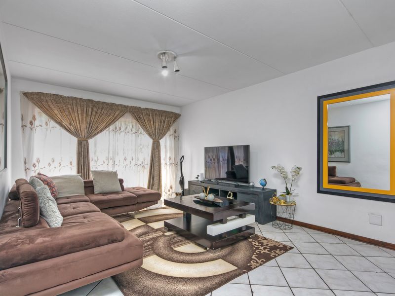 A living room featuring tiled flooring and a ceiling-mounted light fixture, offering a functional space for relaxation.