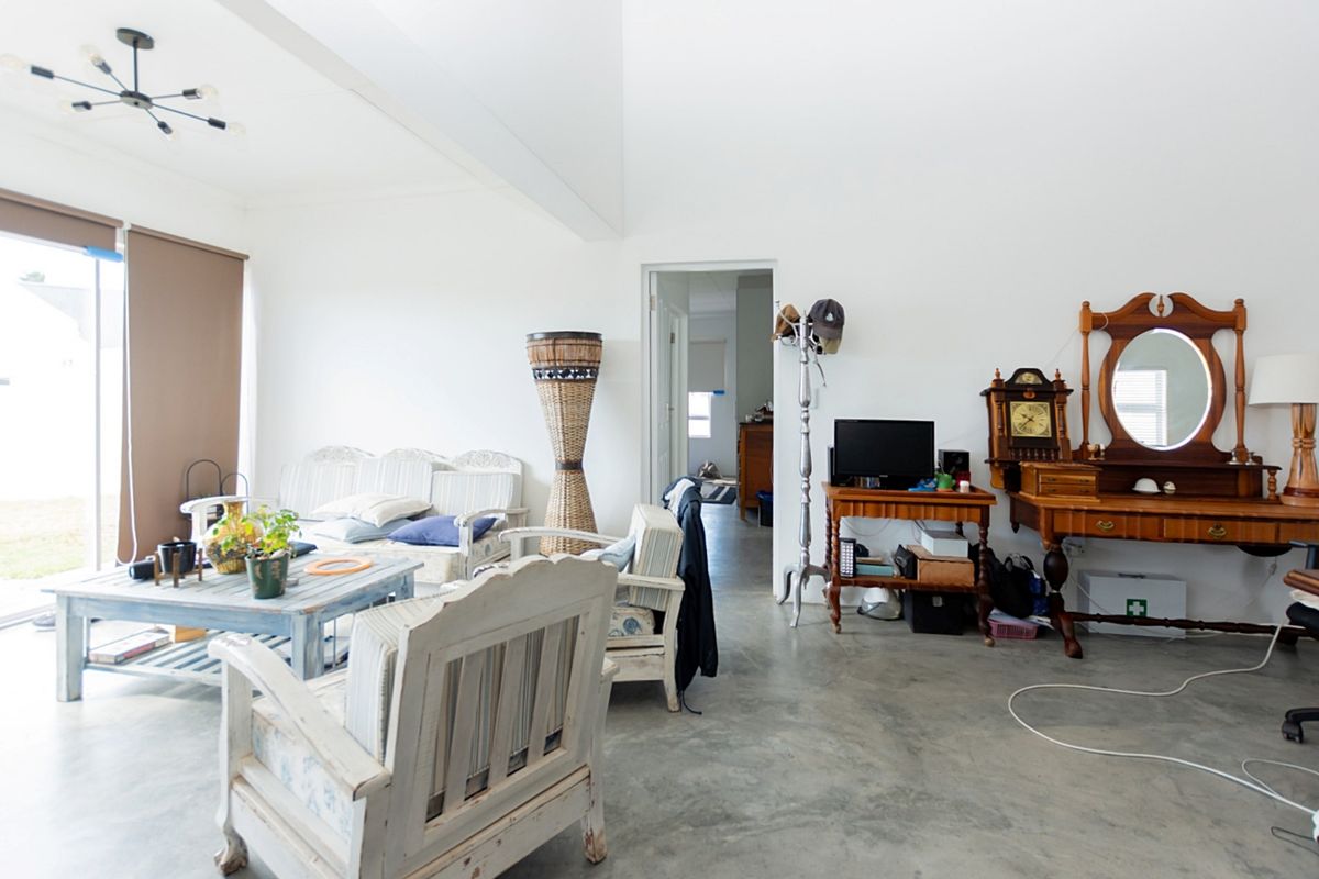 Spacious living area featuring polished concrete floors and a large sliding glass door providing natural light and access to the exterior.