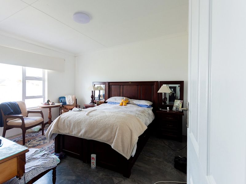 A functional bedroom featuring a window and neutral wall finishes, offering a comfortable space for rest.