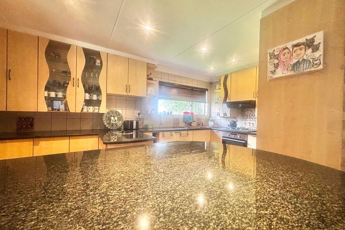 A functional kitchen featuring granite countertops, ample built-in cabinetry, and integrated appliances, offering a practical workspace with recessed lighting.