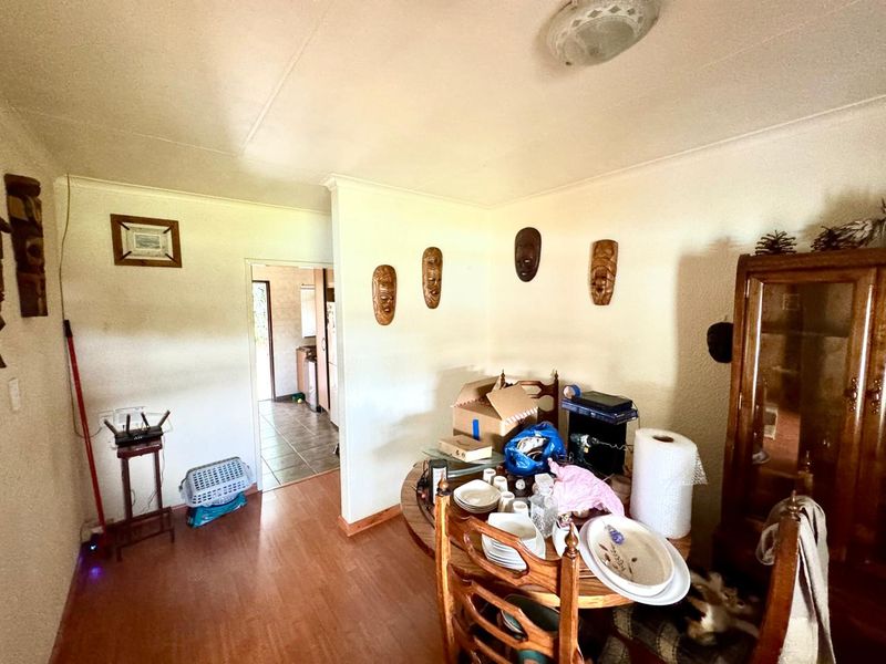 Dining area featuring laminate flooring and coved ceilings, providing a functional space with direct access to the adjacent kitchen area.