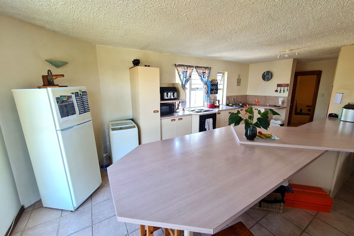 A functional kitchen featuring built-in cabinetry, laminate countertops, a built-in oven, and tiled flooring, offering a practical layout with a breakfast bar area.