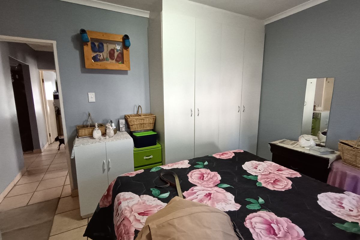 A bedroom featuring built-in white cabinetry and tiled flooring, providing functional storage space within the room.