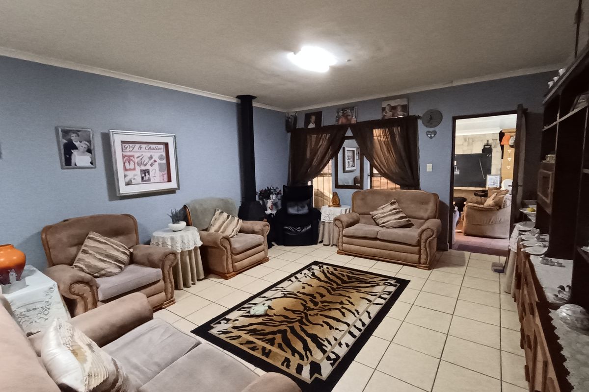 A spacious living room featuring tiled flooring and a built-in fireplace, providing a comfortable and functional living area.