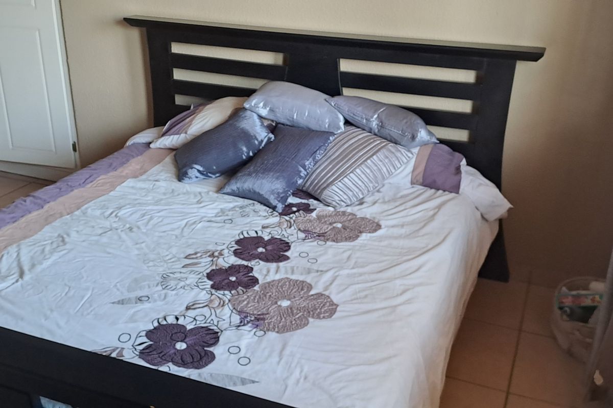 A bedroom featuring tiled flooring and built-in cupboards.