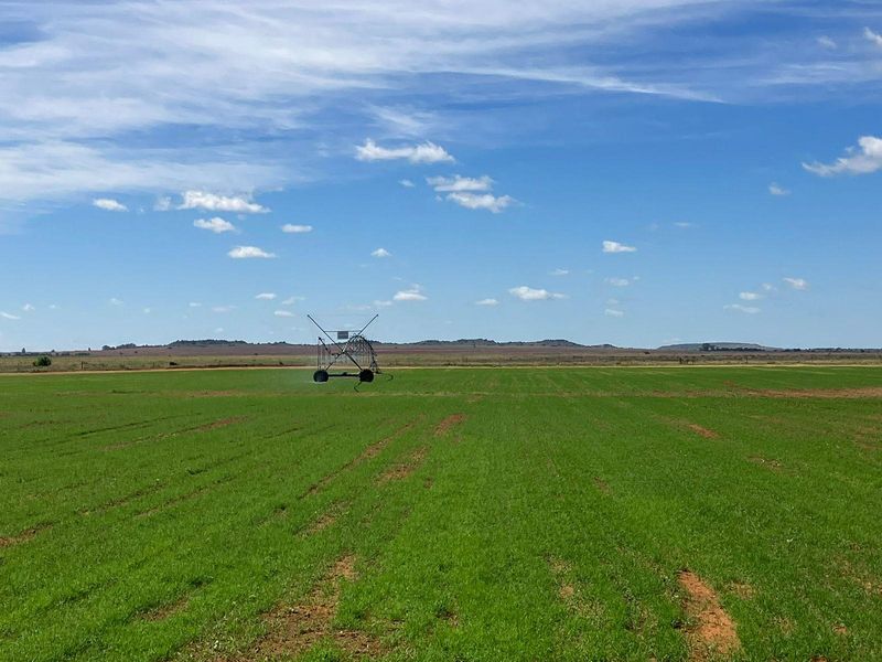 Expansive agricultural farmland featuring a central pivot irrigation system, showcasing the property's productive land and irrigation infrastructure.