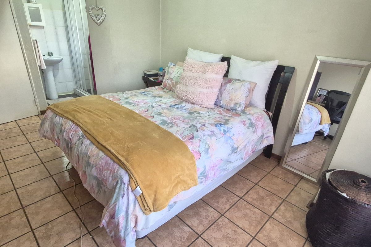 A bedroom featuring tiled flooring and direct access to an en-suite bathroom.